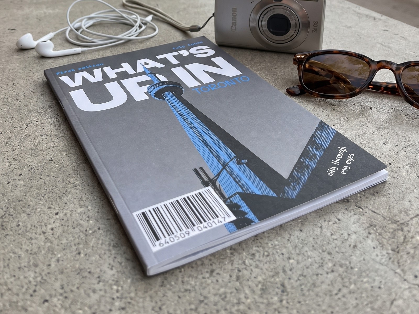 What's Up In Toronto zine cover, close up on a concrete patio table